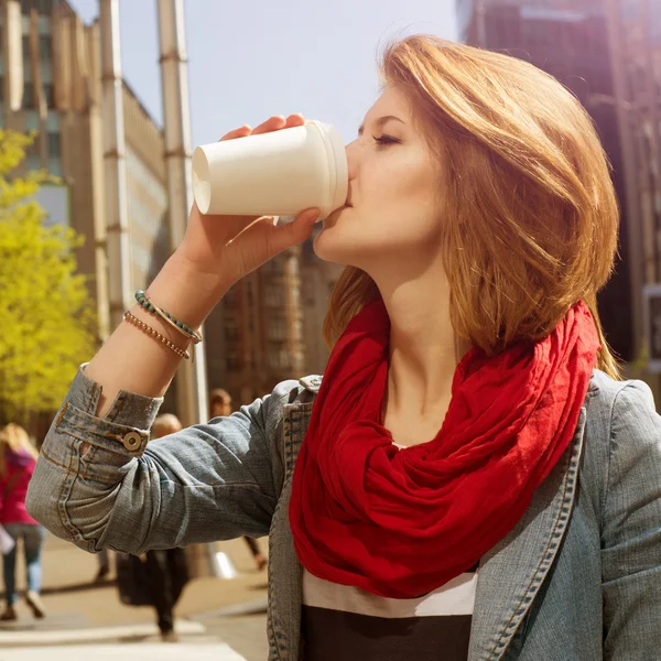 Atractiva joven bebiendo una bebida caliente de una taza de papel — Foto de Stock