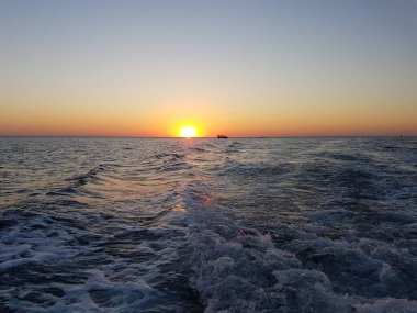 Dünyanın farklı yerlerinde denizin üzerinde gün batımı.