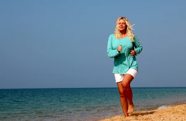 समुद्र तट पर दौड़ने वाली महिला — स्टॉक फ़ोटो, इमेज