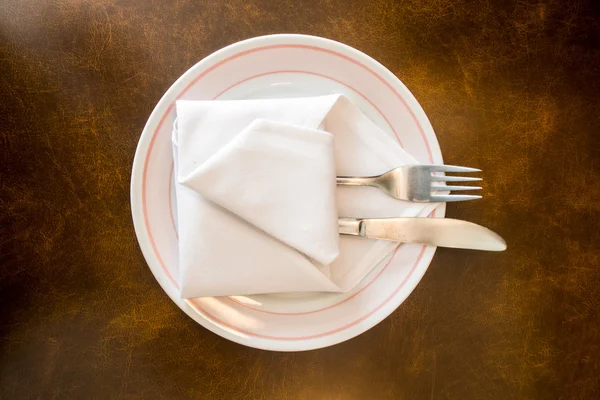 Empty plate and fork on wood table — Stock Photo, Image