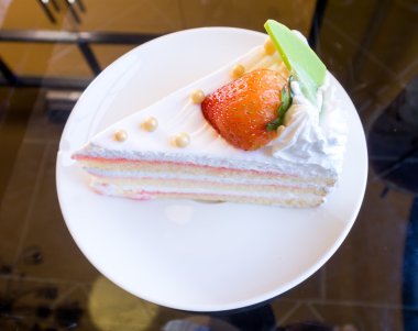 Çilekli pasta üzerinde beyaz bir tabak.