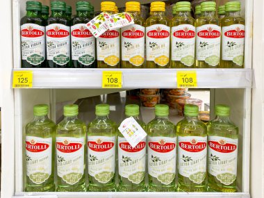 Bangkok Tayland - 6 Nisan 2022: Tesco Lotus Srinakarin şubesindeki raflarda çok sayıda zeytinyağı markası