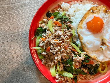 Kızarmış domuz ve fesleğenli pilav ve masada kızarmış yumurta.