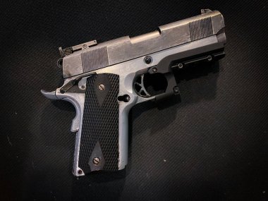 Kumaş arka planında eski ve kirli bir tabanca.