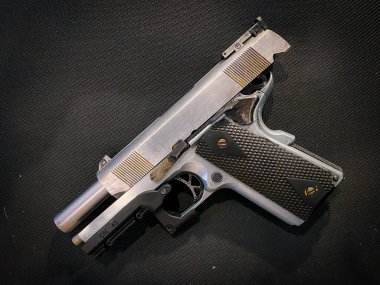 Kumaş arka planında eski ve kirli bir tabanca.