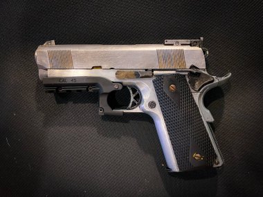 Kumaş arka planında eski ve kirli bir tabanca.