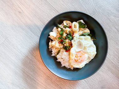 Üzerine kızarmış kalamar ve fesleğen ve sahanda yumurta.