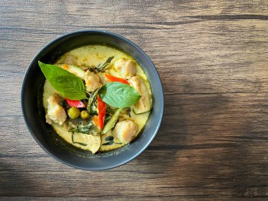 Tahta arka planda yeşil körili tavuk..