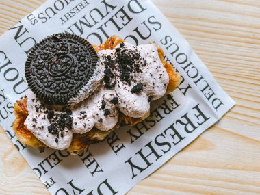 Croffle with cookie and cream on top on the table