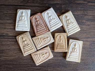 Tahta arka planda izole edilmiş Tayland Buda tılsımı..