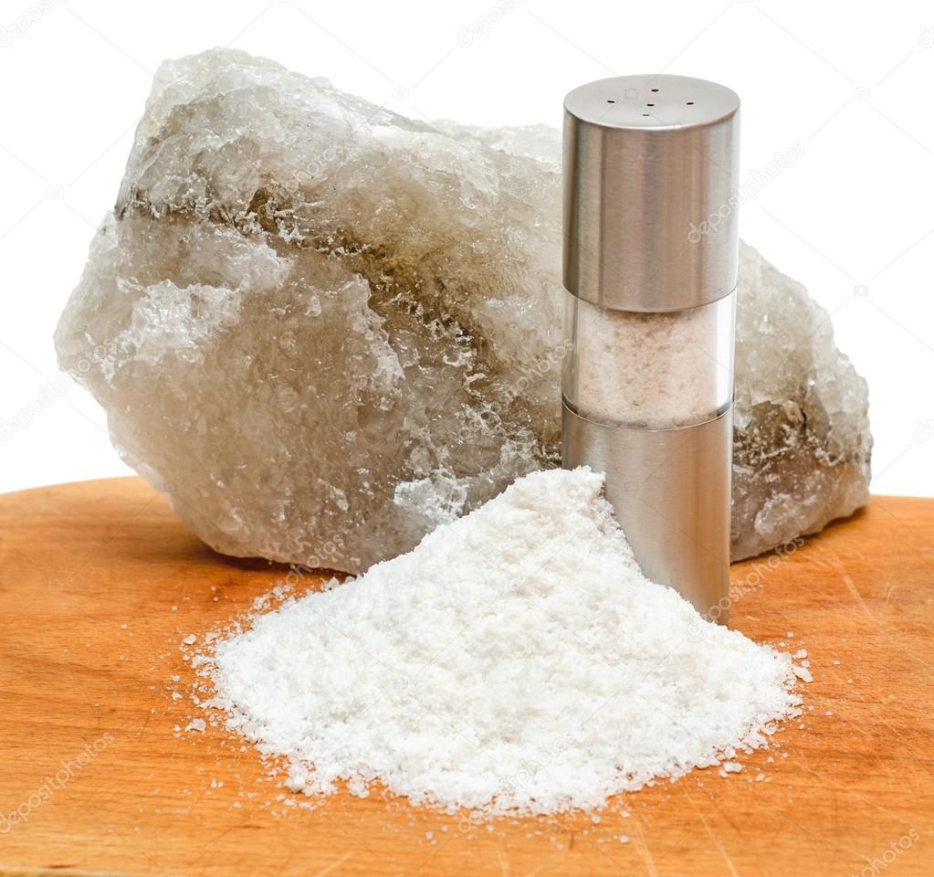 Rock salt with saltshaker and scattered salt