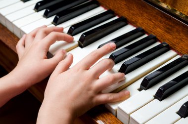 Child hands playing piano clipart