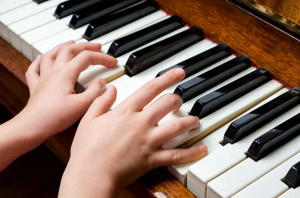 Main d'enfant jouant du piano — Photo