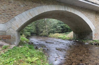 Küçük bir nehir üzerinde yeni bir köprü. Yaz zamanı. Rekonstrüksiyondan sonra küçük beton köprü. Yeni asfalt.