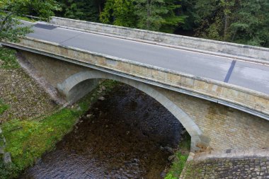 Küçük bir nehir üzerinde yeni bir köprü. Yaz zamanı. Rekonstrüksiyondan sonra küçük beton köprü. Yeni asfalt.