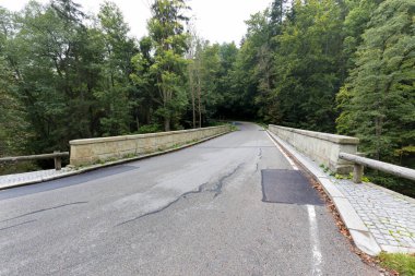 Küçük bir nehir üzerinde yeni bir köprü. Yaz zamanı. Rekonstrüksiyondan sonra küçük beton köprü. Yeni asfalt.