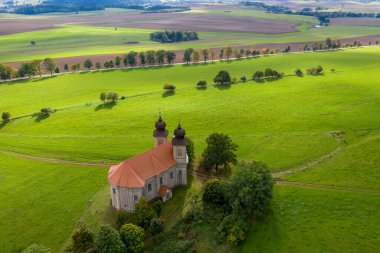 18. yüzyıldan kalma St. Margaret Kilisesi, Aonov yakınlarında. Czech kırsal kesiminde arkaplanda dağlarca duvar olan güzel bir kilise şapeli. Hava görünümü