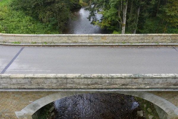 new bridge across a small river. Summer time. Small reinforced concrete bridge after reconstruction. New asphalt.