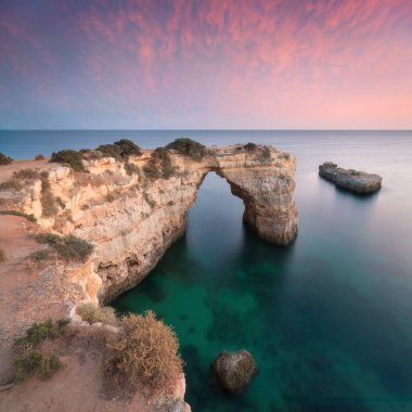 Okyanusun üzerindeki doğal kemer. Marinha sahilindeki doğal mağaralar, Algarve, Lagoa Portekiz. Sahilde taş kemer. Yaz mevsimi.