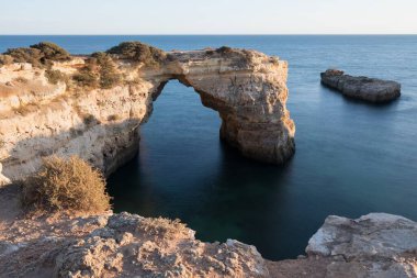 Okyanusun üzerindeki doğal kemer. Marinha sahilindeki doğal mağaralar, Algarve, Lagoa Portekiz. Sahilde taş kemer. Yaz mevsimi.