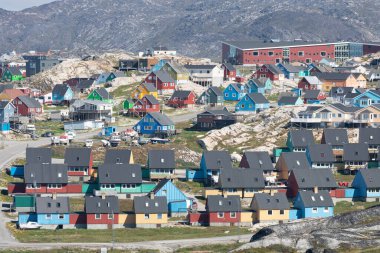 Greenland view of colorful houses in Ilulissat City and icefjord. Tourist destination in the arctic. Panoramic photo of typical Greenland village houses. Rodebay