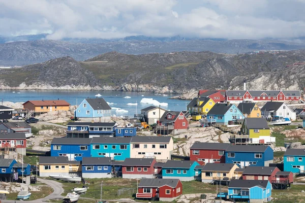 Greenland view of colorful houses in Ilulissat City and icefjord. Tourist destination in the arctic. Panoramic photo of typical Greenland village houses. Rodebay