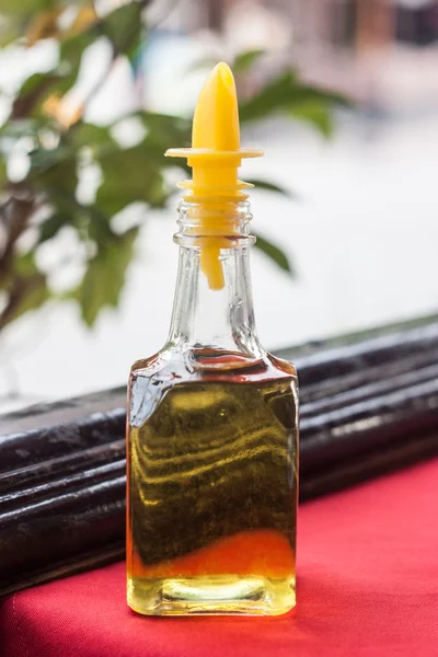 Соус из оливкового масла. на красном столе — стоковое фото