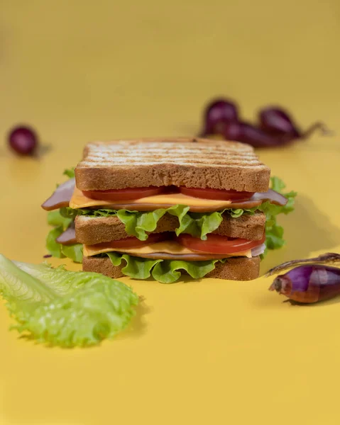 Traditionell smörgås gjord på skivor rostat bröd, ost, skinka, färsk sallad. Firar den nationella smörgåsdagen. — Stockfoto