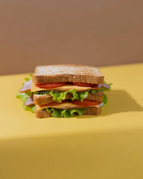 Traditionell smörgås gjord på skivor rostat bröd, ost, skinka, färsk sallad. Firar den nationella smörgåsdagen. — Stockfoto
