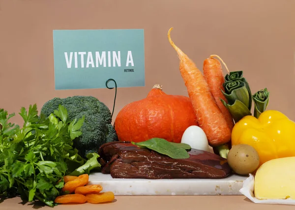 A set of natural products rich in vitamin A retinol. Healthy food concept. Cardboard sign with the inscription. Beige background.