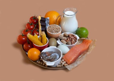 Elimination diet concept. Food allergens on plate - fish, seafood, dairy, peanuts, tree nuts, eggs, chocolate, wheat, soy, citrus fruits. clipart