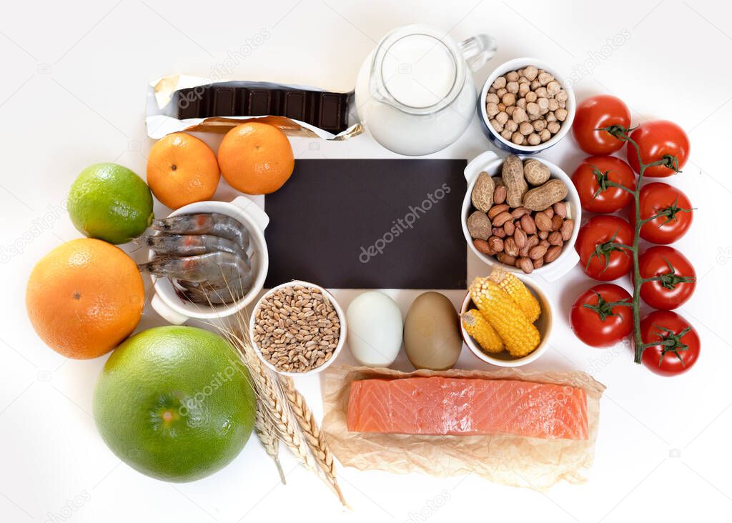 Elimination diet concept. Food allergens on plate - fish, seafood, dairy, peanuts, tree nuts, eggs, chocolate, wheat, soy, citrus fruits.