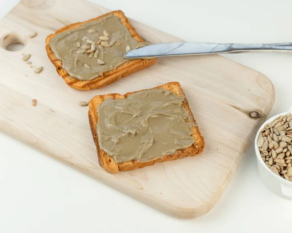 Pan tostado Untar Mantequilla de girasol orgánica. Un manjar delicioso, cremoso y salado. Alternativa hipoalergénica a la mantequilla de maní. — Foto de Stock