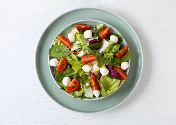 Marul, ıspanak, roka, mozzarella ve vişneli domatesli diyet ve sağlıklı salata. Ulusal Salata Ayı konsepti. Üst görünüm