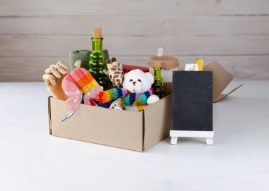 Ulusal Bağış Günü konsepti. El sanatları kutusunda çeşitli oyuncaklar ve hediyeler. Bağış kutusu. Garaj satışı. Boşluğu kopyala.