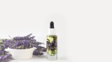 Cam bir şişe lavanta yağı taze lavanta çiçekleri ve beyaz arka planda kurutulmuş lavanta tohumları aromaterapi masaj konsepti. Lavandula oleum. Pankart.