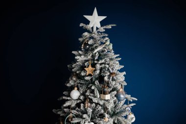 Güzel karlı Noel ağacı, tatil için güzel süslerle mavi bir zemin oluşturur.. 
