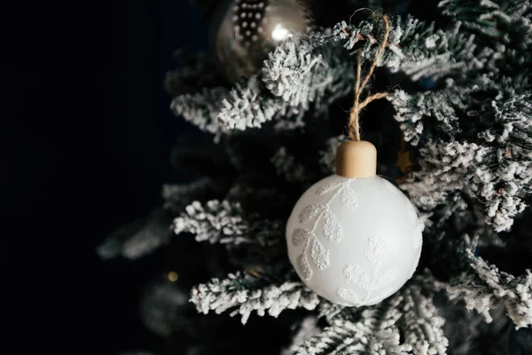 Bela Bugiganga Natal Com Penas Uma Árvore Nevada Contra Fundo — Fotografia de Stock