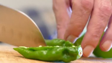 Cutting jalapenos in the kitchen. Cutting jalapenos in the cutting board preparing the dinner