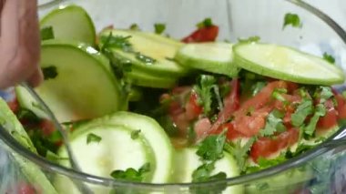 Preparing the zucchini casserole for the oven. Mixing zucchini, tomatoes and vegetables ingredients in the bowl ready to bake