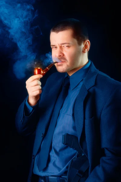 Mann mit Waffe rauchte Pfeife — Stockfoto