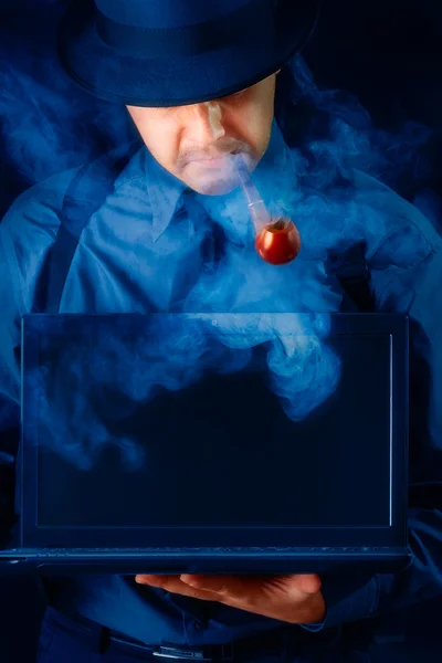 Mann mit Hut und Pfeife hält Laptop mit schwarzem Bildschirm — Stockfoto