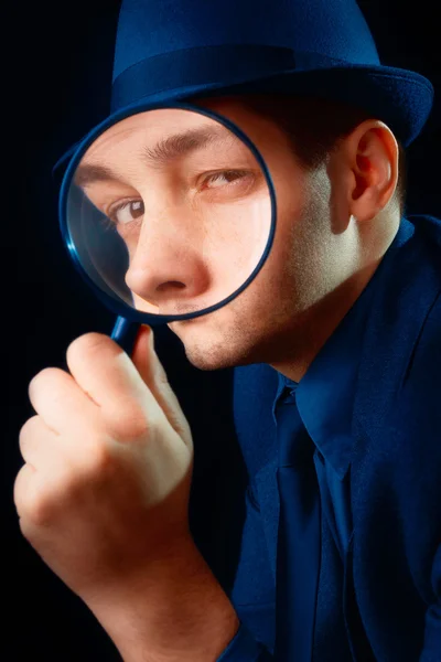 Mann schaut durch Vergrößerungsglas — Stockfoto