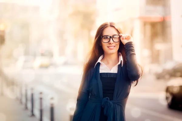 Ung kvinna med glasögon i staden — Stockfoto