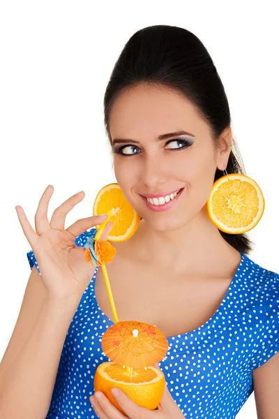 Девушка с апельсиновым напитком и оранжевый ломтик серьги белый фон — стоковое фото