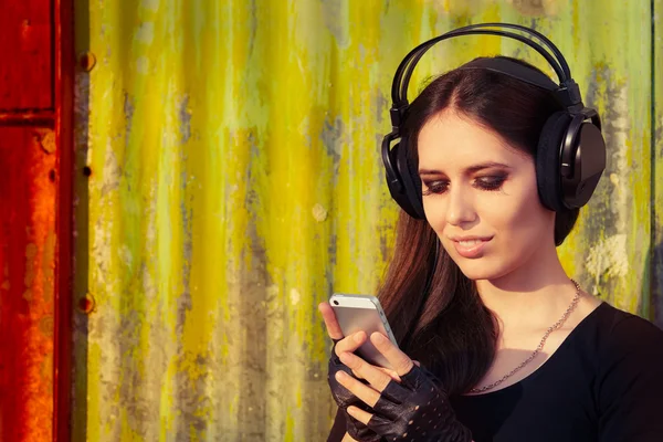 Girl with Big Headphones and Smart Phone on Grunge Background — Stock Photo, Image