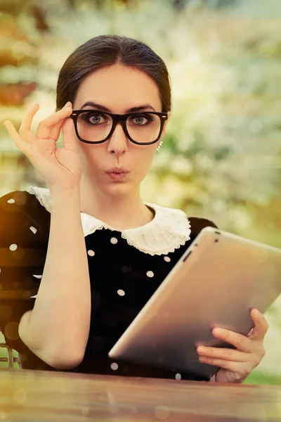 Překvapený mladá žena s brýlemi a tablet — Stock fotografie