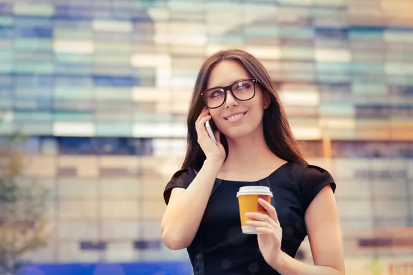 Młoda kobieta z kubkiem kawy w telefonie w mieście — Zdjęcie stockowe