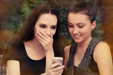 Young Women Surprised by Text Message clipart