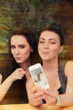 Young Women Taking a Funny Selfie Together clipart